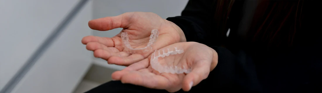 A person holding Invisalign in their hands.