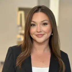sleek haired staff member wearing a black blazer over a white top